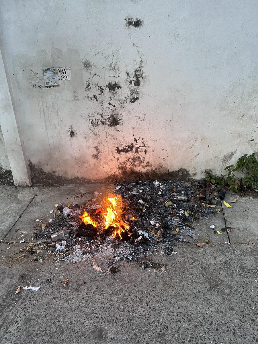a pile of trash burning on the sidewalk
